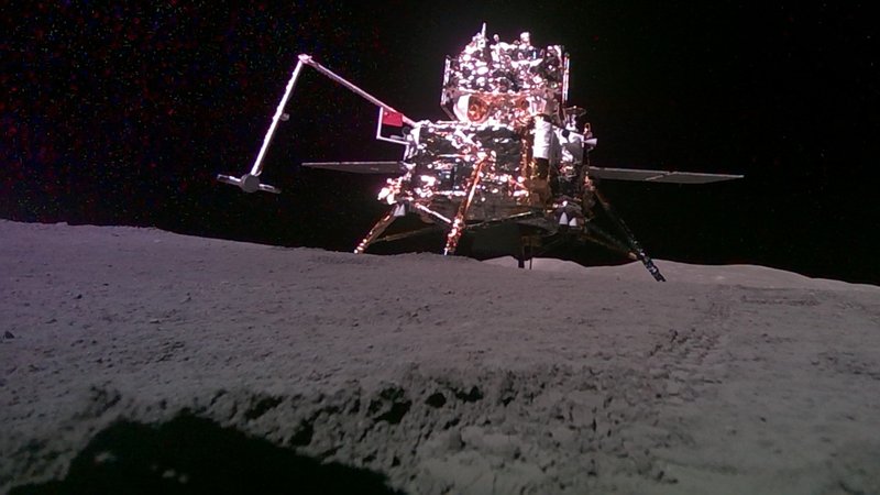 Auf grauem, steinigen Boden steht eine glänzende Mondlandefähre mit vier Beinen, einem Arm mit Gelenk und Solarpaneelen. | Bild: picture alliance / Xinhua News Agency | Jin Liwang Auf grauem, steinigen Boden steht eine glänzende Mondlandefähre mit vier Beinen, einem Arm mit Gelenk und Solarpaneelen.