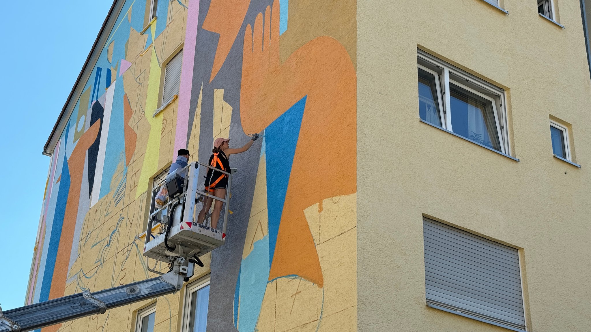 Die Künstler Claire Prouvost und Soihe beim Bemalen der Hauswand.