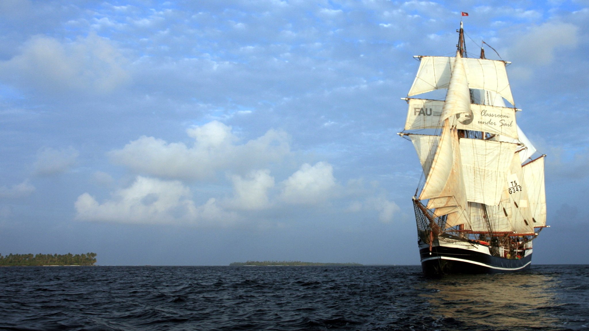 Ein Segelschiff auf dem Meer vor blauem Himmel.