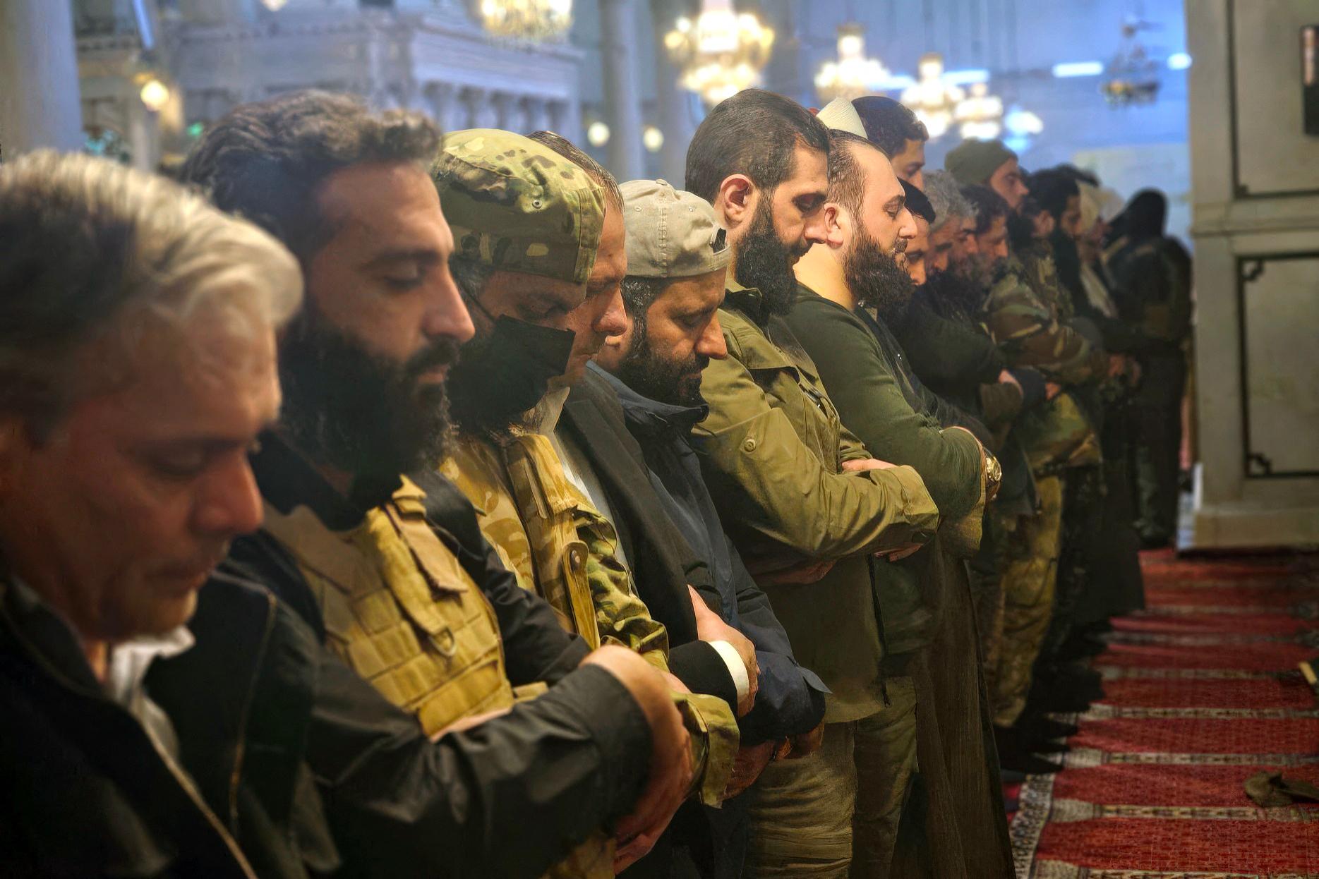 Hochrangige Mitglieder der islamistischen HTS-Miliz beten nach der Einnahme der syrischen Hauptstadt (Aufnahme vom 09.12.2024)