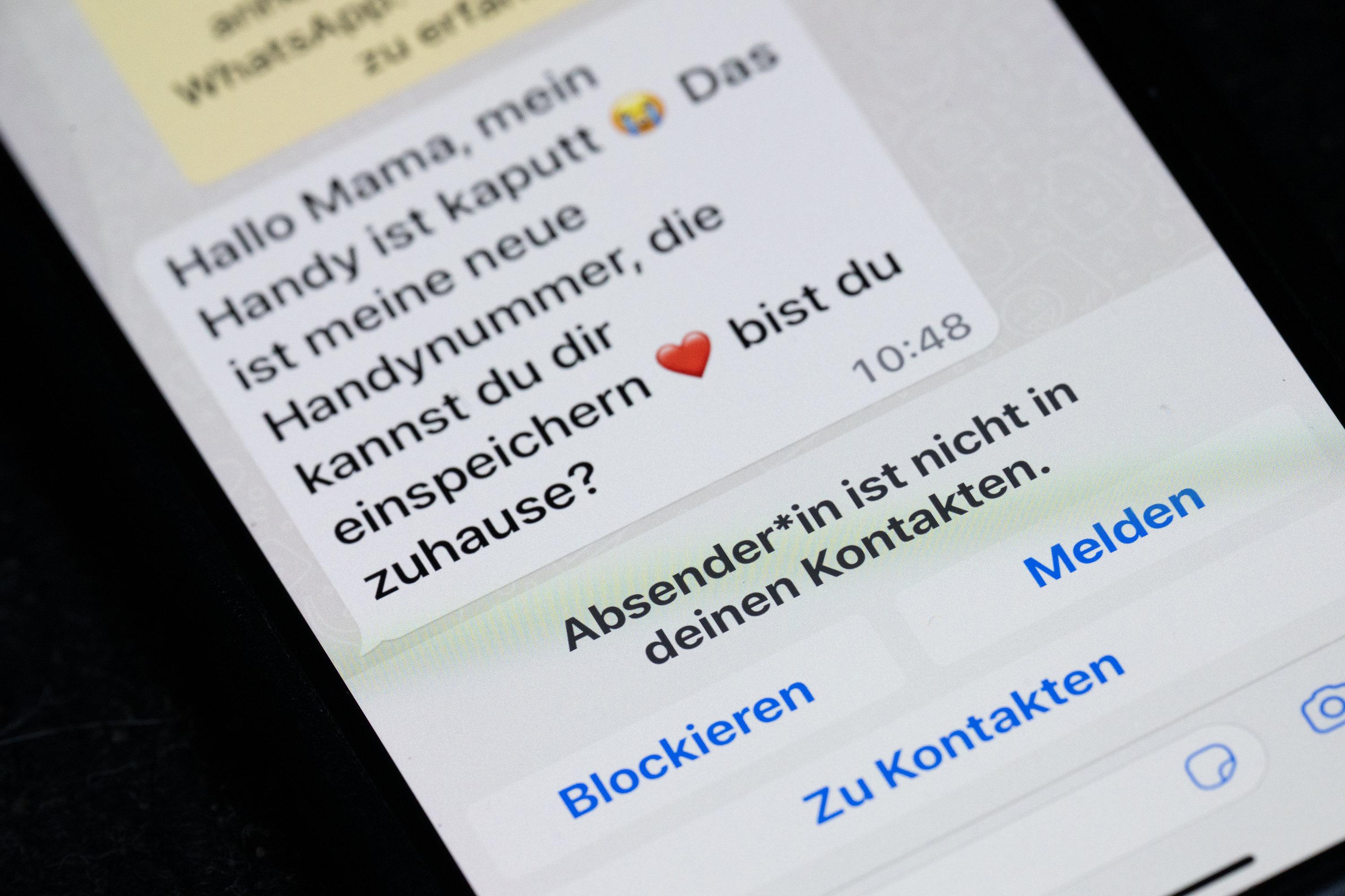 Symbolbild Trickbetrug: Auf dem Display eines Smartphones steht eine Whats App-Nachricht, die im Tonfall betrügerischen Nachrichten nachempfunden ist, die dazu genutzt werden, Geld zu bekommen.