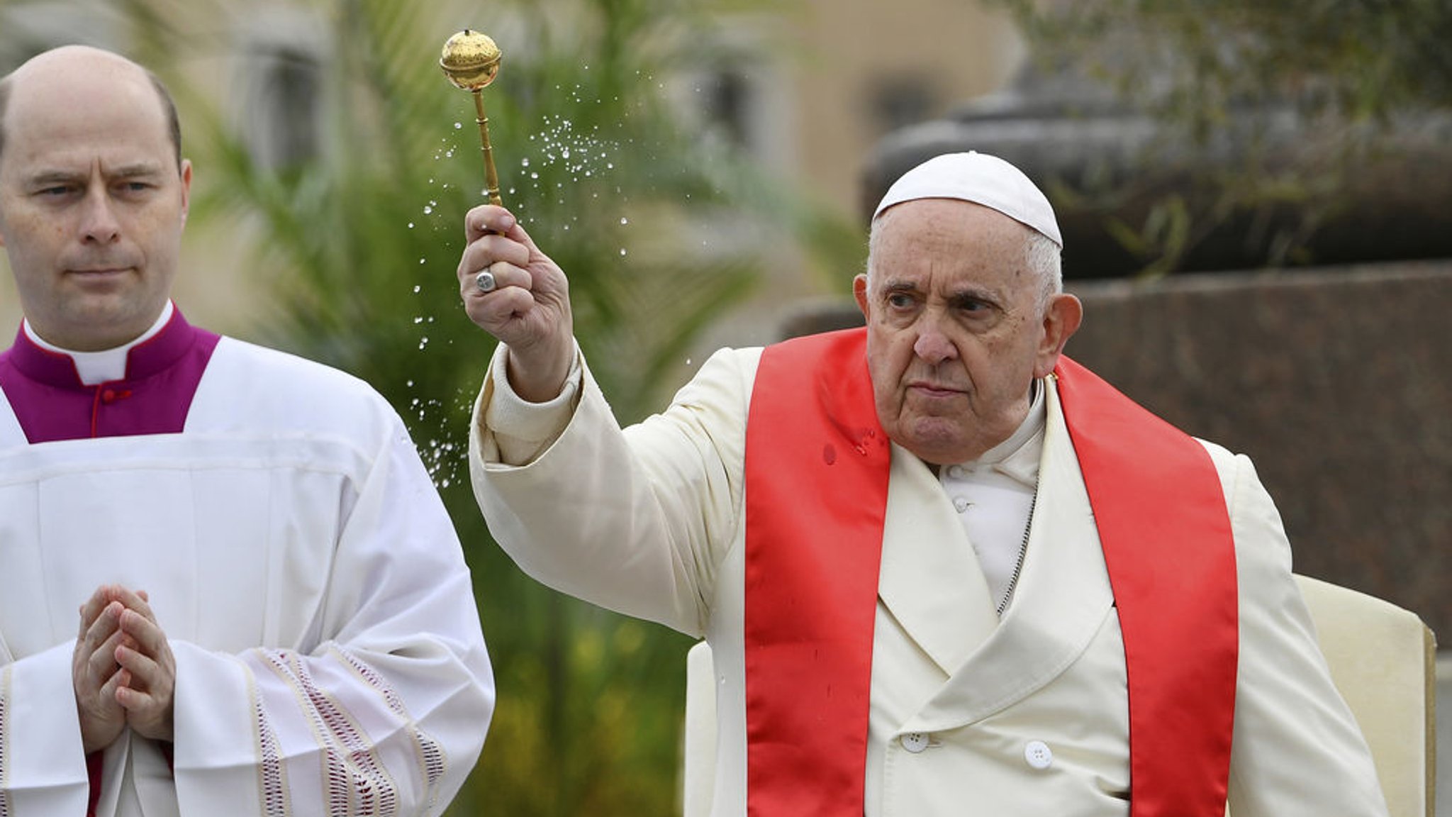 02.04.2023, Vatikan, Vatikanstadt: Papst Franziskus (r) segnet die Gläubigen mit Oliven- und Palmzweigen, bevor er die Palmsonntagsmesse auf dem Petersplatz im Vatikan zelebriert, einen Tag nachdem er aus dem Krankenhaus in Rom entlassen wurde, wo er wegen einer Bronchitis behandelt wurde. Der Palmsonntag ist der sechste und letzte Sonntag der christlichen Fastenzeit und der Beginn der Karwoche. Foto: Gregorio Borgia/AFP/AP/dpa +++ dpa-Bildfunk +++