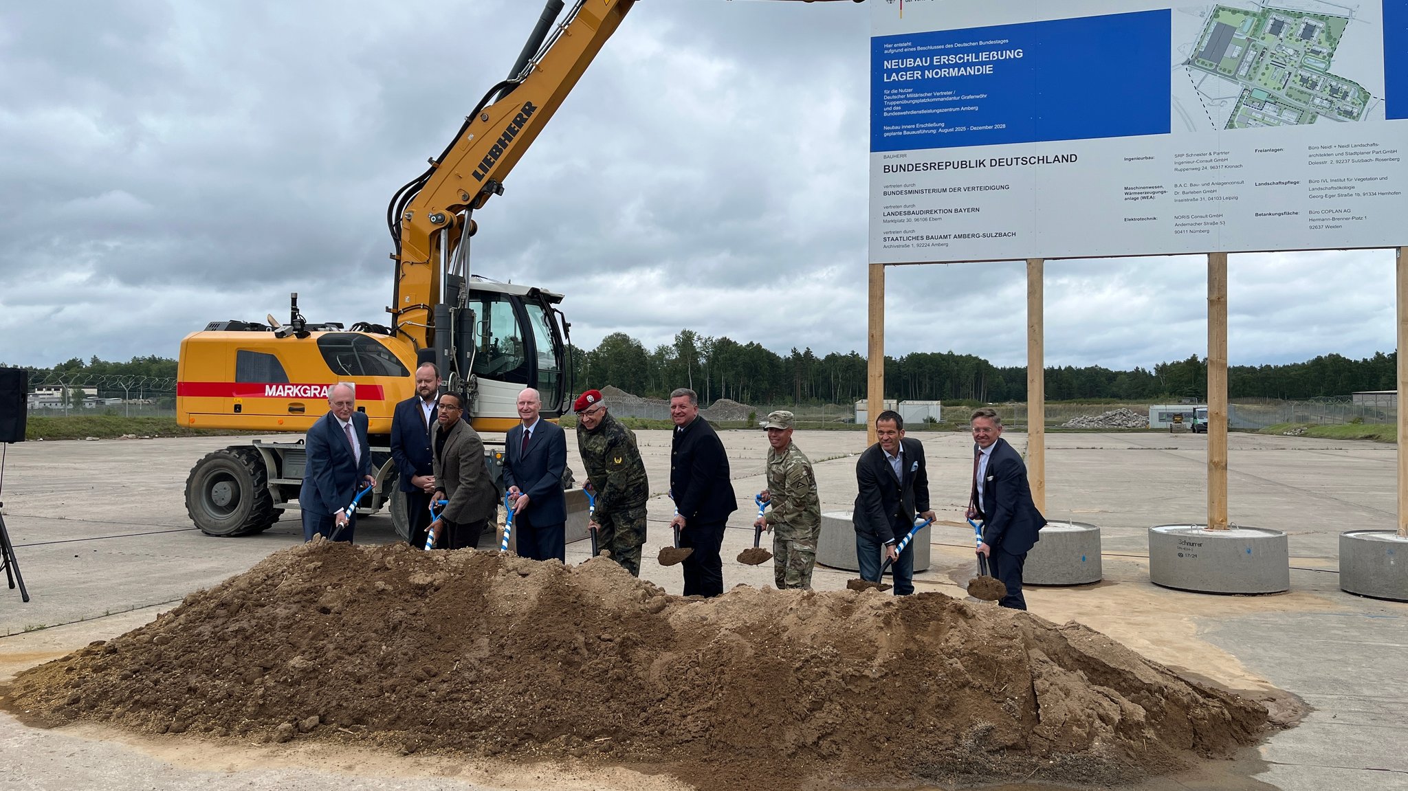 Beim Spatenstich auf der Baustelle werden die Verantwortlichen symbolisch einen Spaten voll Erde in die Luft. 
