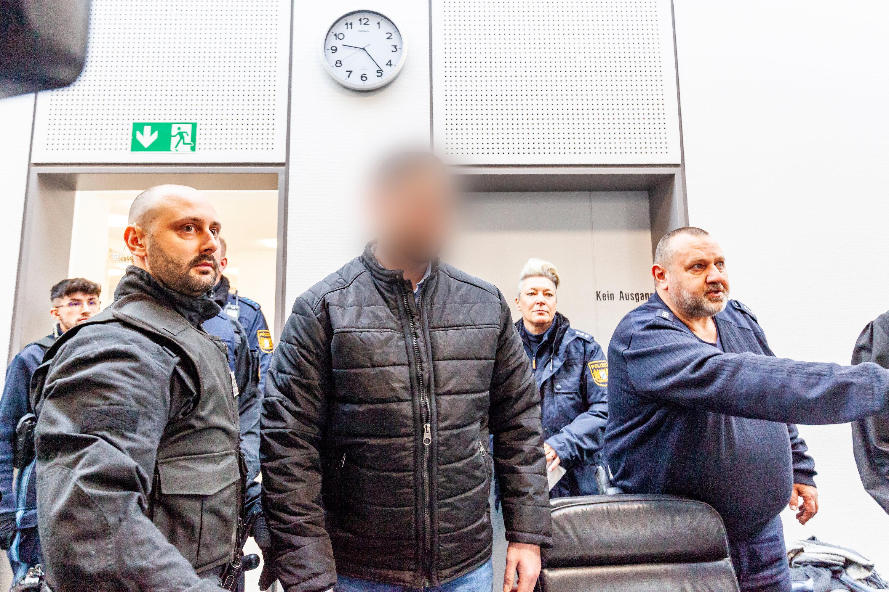 Ein angeklagter 25-Jähriger (m.) kommt zum Mordprozess um die Tötung einer Doppelgängerin (Archivbild)