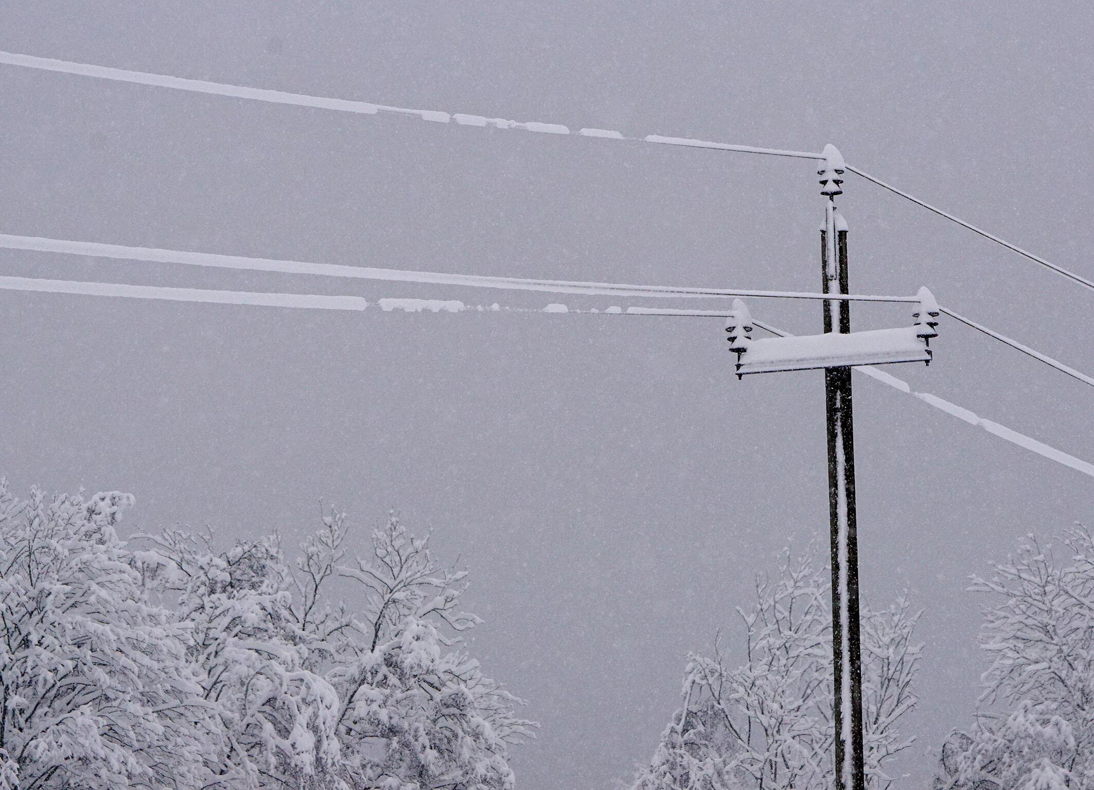 Symbolbild: Schnee auf einer Stromleitung