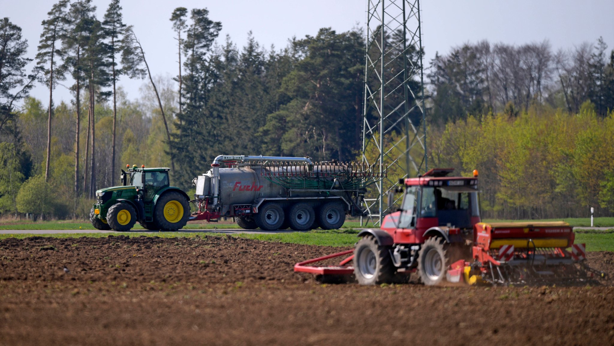 Stockheim bei Bad Woerishofen, Ein Landwirt saet Getreide auf seinem Feld aus. Dahinter faehrt ein anderer mit dem Guellefass vorbei. | Bild: picture alliance / MIS | Sportpressefoto M.i.S. Stockheim bei Bad Woerishofen, Ein Landwirt saet Getreide auf seinem Feld aus. Dahinter faehrt ein anderer mit dem Guellefass vorbei.