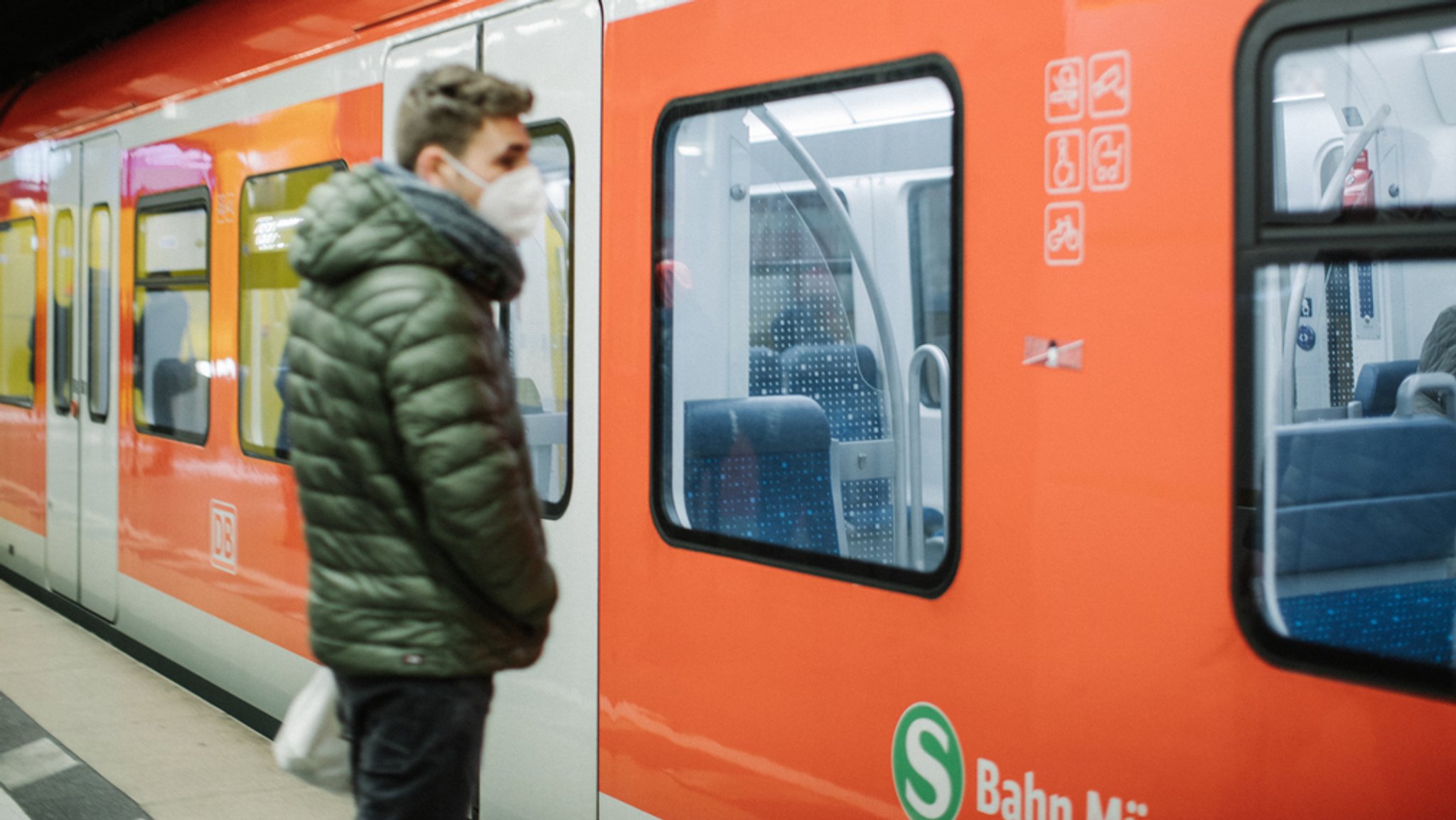 Ein Mann mit FFP2-Maske steht vor einem S-Bahnzug (Symbolbild).