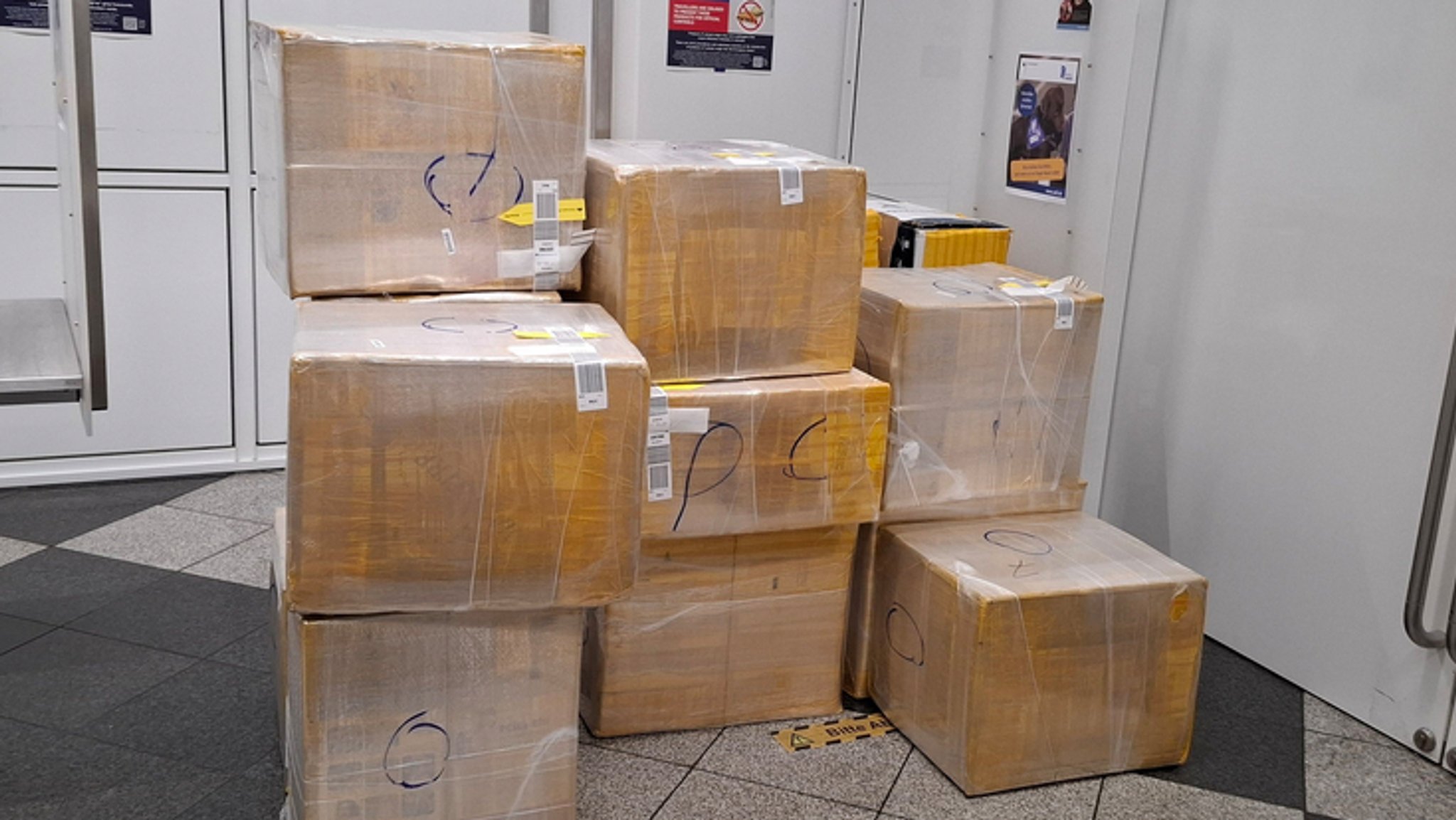 Mehrere große und fest verpackte Kisten in einem Raum des Münchner Flughafens. Hunderttausende Zigaretten, verpackt in mehrere große Kisten: So wollte ein Ehepaar am Münchner Flughafen am Zoll vorbei. | Bild: dpa-Bildfunk/Zoll Mehrere große und fest verpackte Kisten in einem Raum des Münchner Flughafens. Hunderttausende Zigaretten, verpackt in mehrere große Kisten: So wollte ein Ehepaar am Münchner Flughafen am Zoll vorbei.
