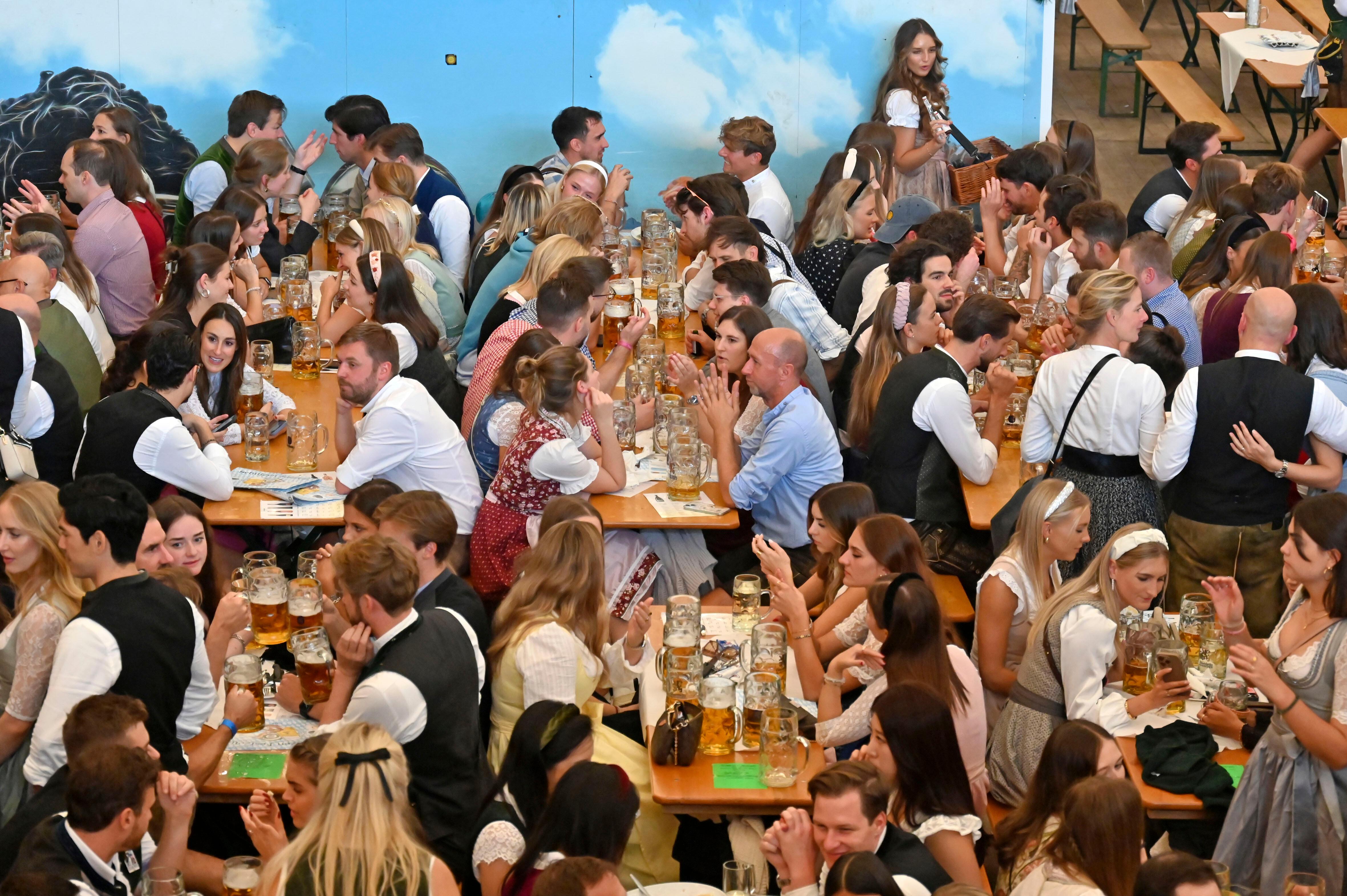 Oktoberfestbild aus dem Jahr 2024: Viele Menschen, die an Biertischen sitzen und trinken