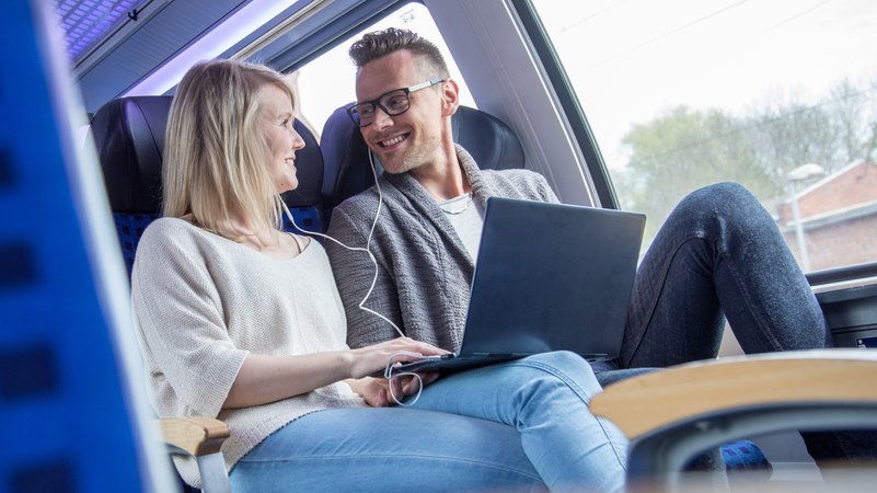 Paar in Zug schaut gemeinsam auf einem Laptop einen Film. | Bild: picture alliance / Christin Klose Paar in Zug schaut gemeinsam auf einem Laptop einen Film.
