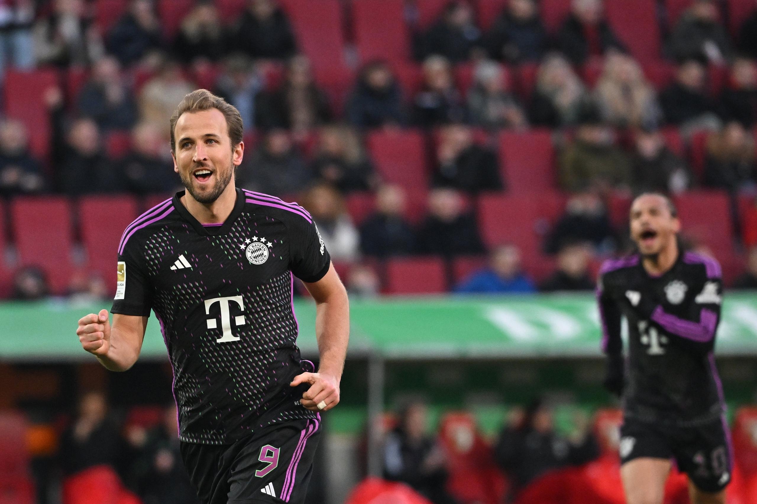 27.01.2024, Bayern, Augsburg: Fußball: Bundesliga, FC Augsburg - Bayern München, 19. Spieltag in der WWK-Arena, Münchens Harry Kane jubelt nach seinem Tor zum 1:3. Rechts ist Leroy Sane. 