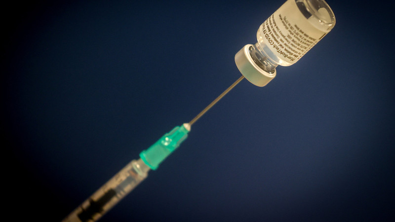  Eine Spritze steckt in einer Ampulle des Corona-Impfstoffes von Pfizer/Biontech. 