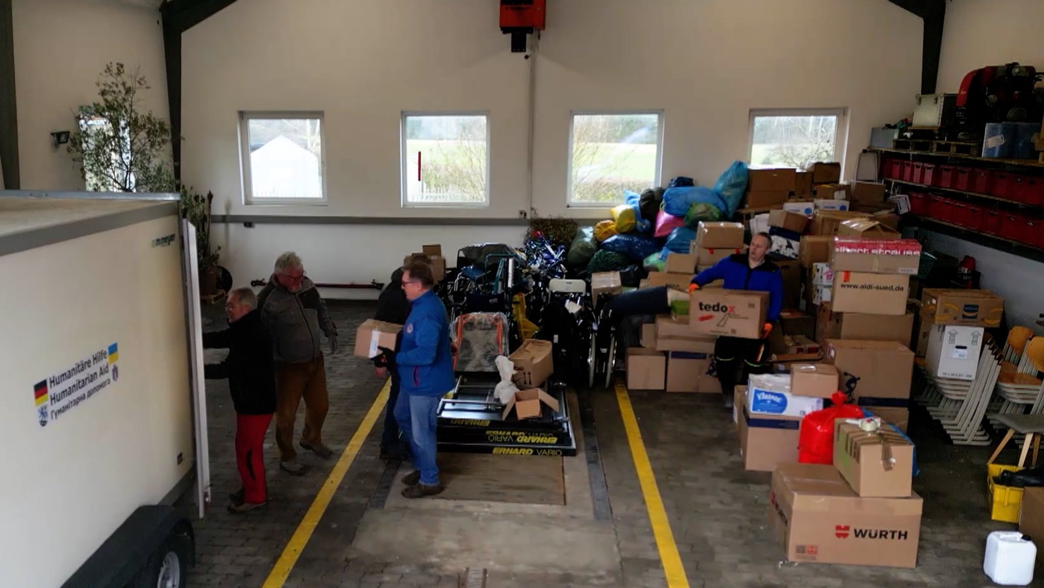 In einer Halle werden Hilfsgüter in einen Transporter geladen.