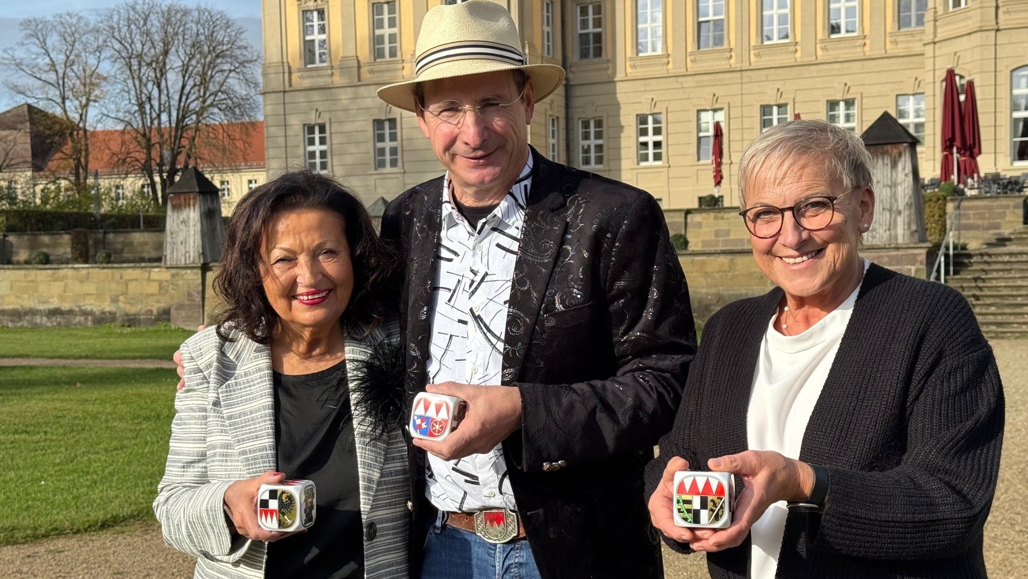 Alice Walchshöfer von Challenge Roth, Kabarettist Oti Schmelzer, die stellvertretende Forchheimer Landrätin Rosi Kraus mit dem Frankenwürfel in der Hand. | Bild: BR/Josef Lindner Alice Walchshöfer von Challenge Roth, Kabarettist Oti Schmelzer, die stellvertretende Forchheimer Landrätin Rosi Kraus mit dem Frankenwürfel in der Hand.