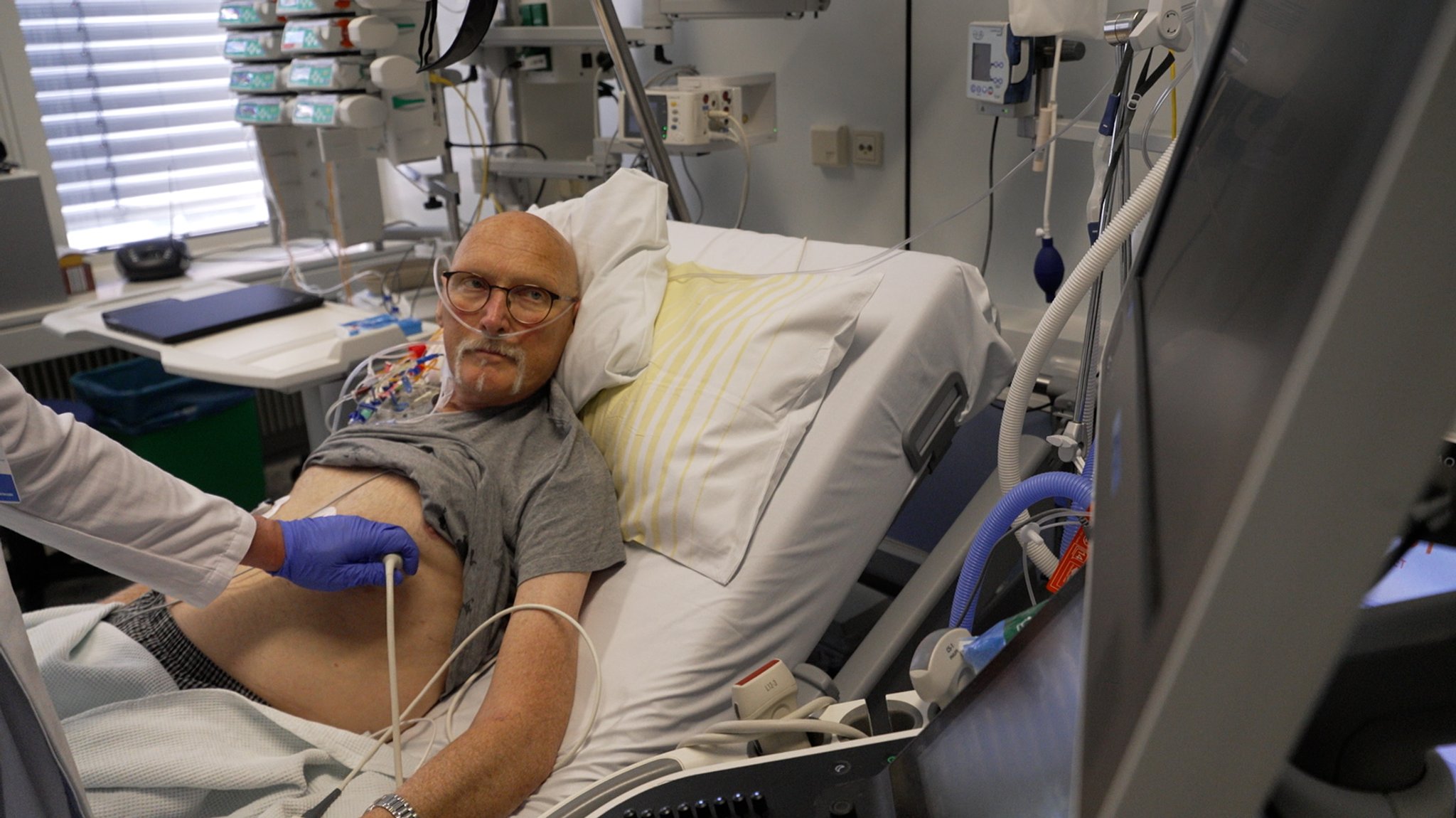 Der Herz-Patient Günter Holzwarth auf der Intensivstation. Er wird von einem Arzt untersucht. | Bild: BR/ Sebastian Sitzberger Der Herz-Patient Günter Holzwarth auf der Intensivstation. Er wird von einem Arzt untersucht.