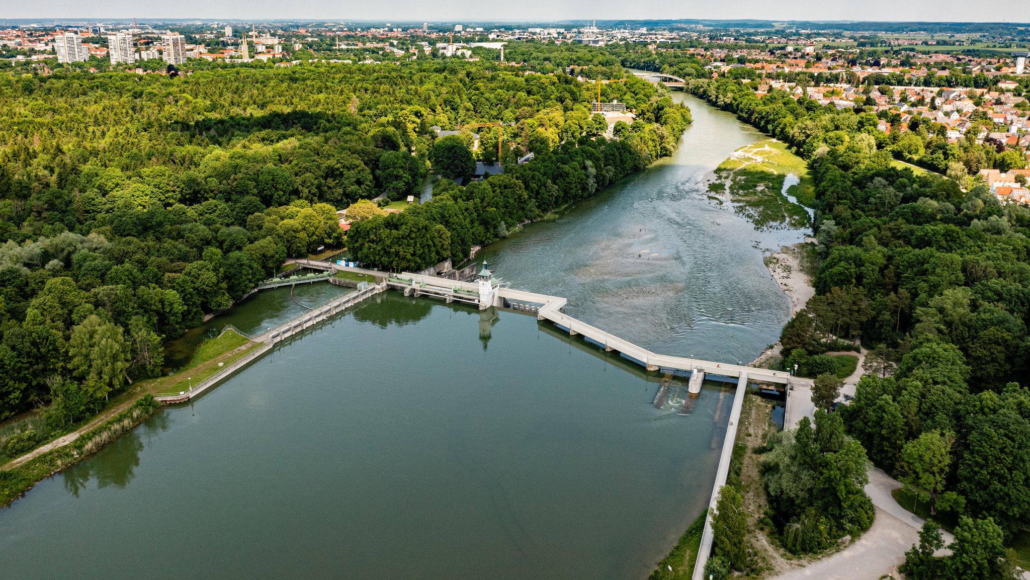 Luftaufnahme der Lechstaustufe Hochablass in Augsburg, umgeben vom Stadtwald. 