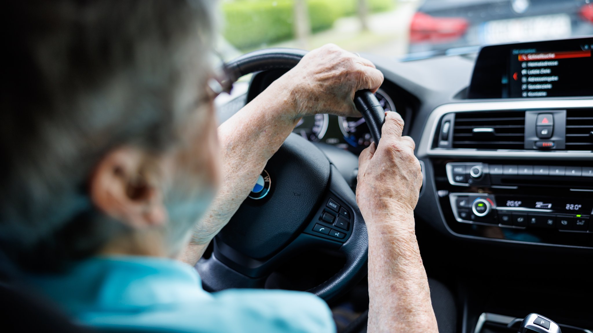 Eine über 90-jährige Frau sitzt am 01.07.2024 hinter dem Lenkrad eines Autos (Symbolbild).