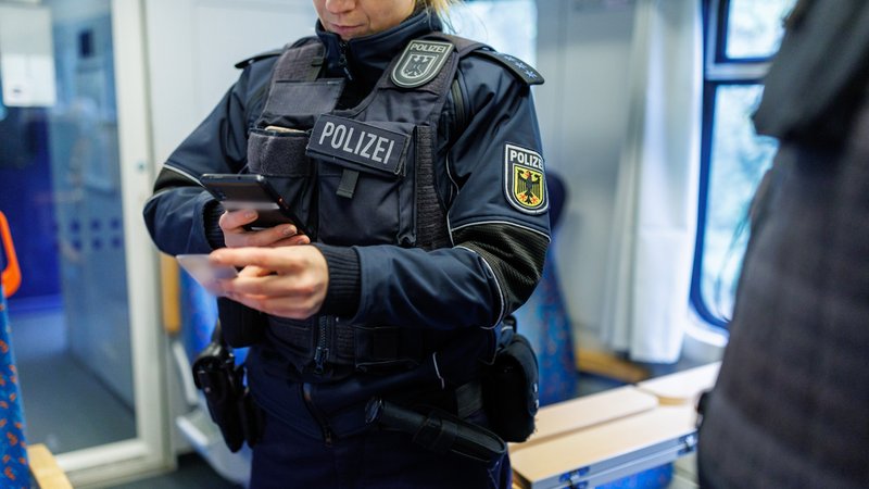Bundespolizisten kontrollieren die Papiere eines Reisenden im Rahmen einer Einreiseverkehrskontrolle in einem Zug aus Prag in Richtung München.