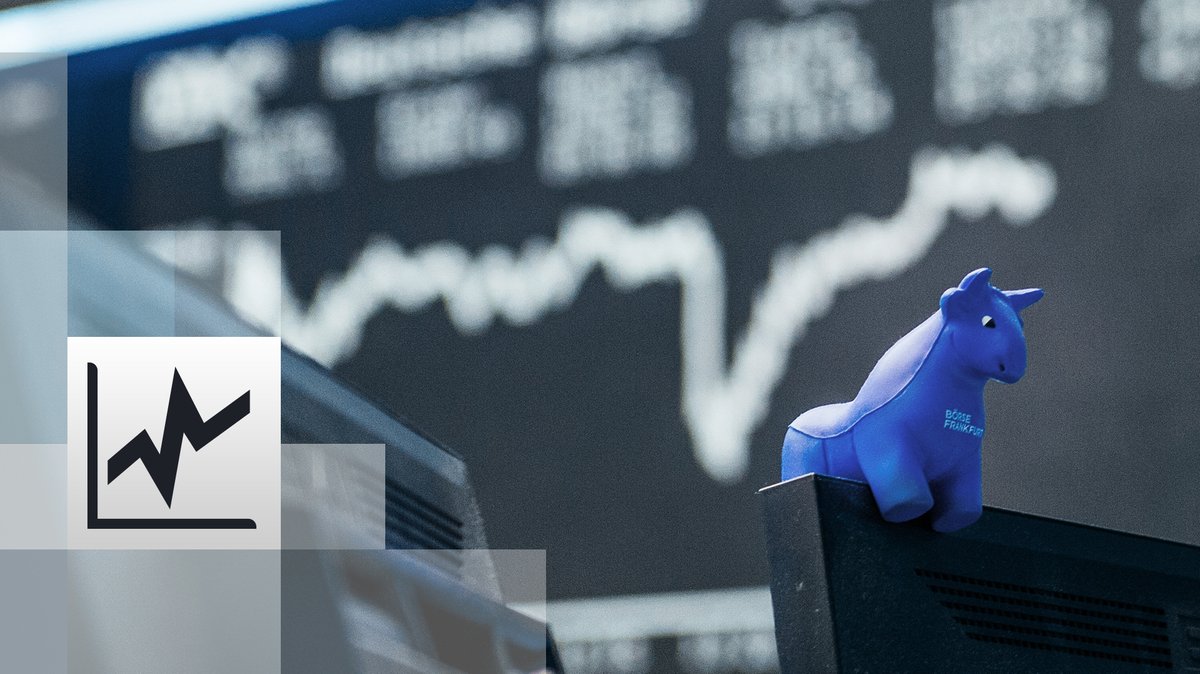 ein blauer Stier aus Gummi sitzt auf der oberen Kante eines Bildschirmes. Im Hintergrund die Kurstafel der Börse