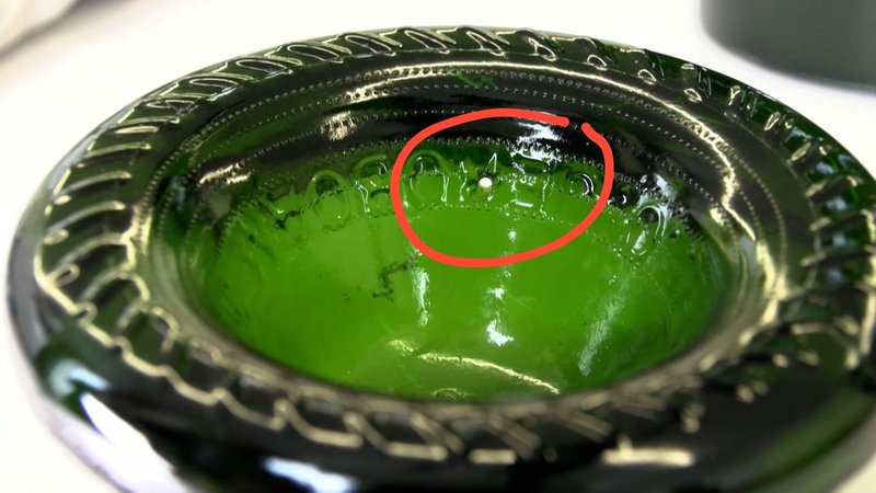 Ein winziges Loch im Flaschenboden: Dadurch soll zunächst der Champagner ausgelassen und anschließend mit flüssigem MDMA befüllt worden sein. | Bild: BR/Margit Ringer Ein winziges Loch im Flaschenboden: Dadurch soll zunächst der Champagner ausgelassen und anschließend mit flüssigem MDMA befüllt worden sein.