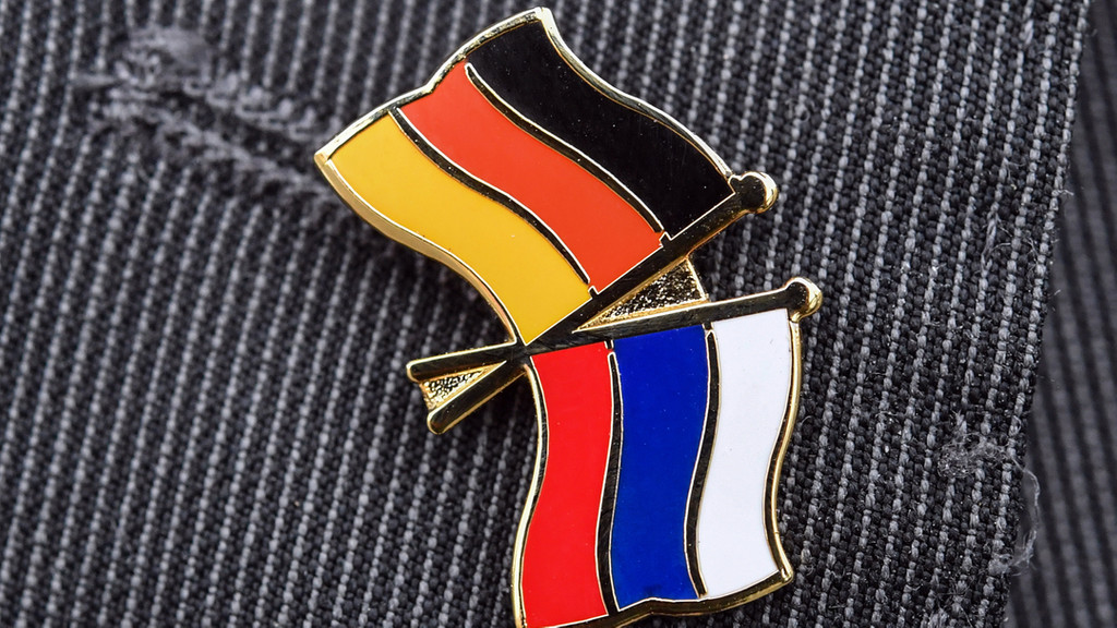 Deutsche und russische Flagge als Anstecker auf einem Kleidungsstück