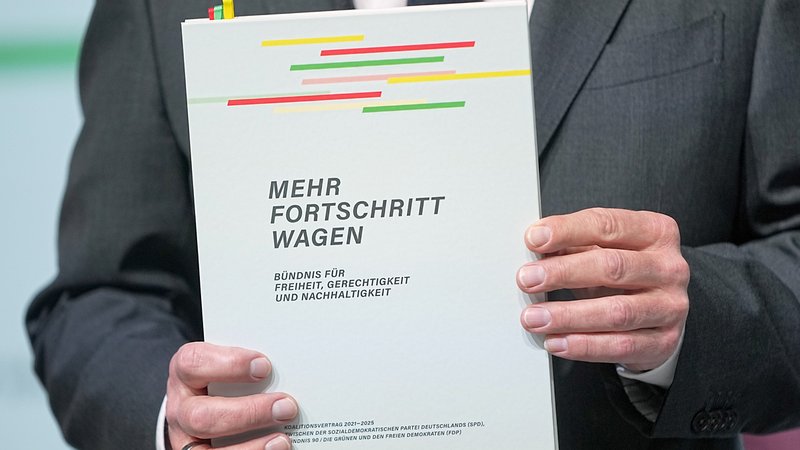 Der Koalitionsvertrag in den Händen von Kanzler Olaf Scholz