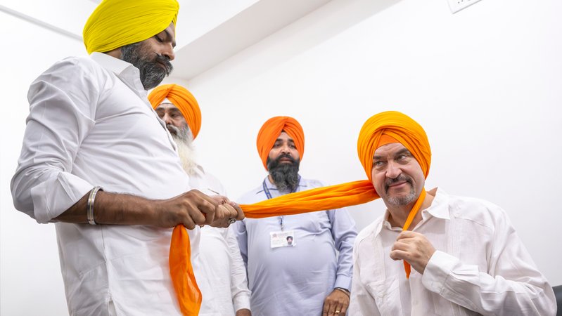 Bayerns Ministerpräsident Markus Söder (CSU), bekommt zu Beginn seines Besuchs des Sikh-Tempels einen orangenen Turban | Bild: picture alliance/dpa | Peter Kneffel Bayerns Ministerpräsident Markus Söder (CSU), bekommt zu Beginn seines Besuchs des Sikh-Tempels einen orangenen Turban