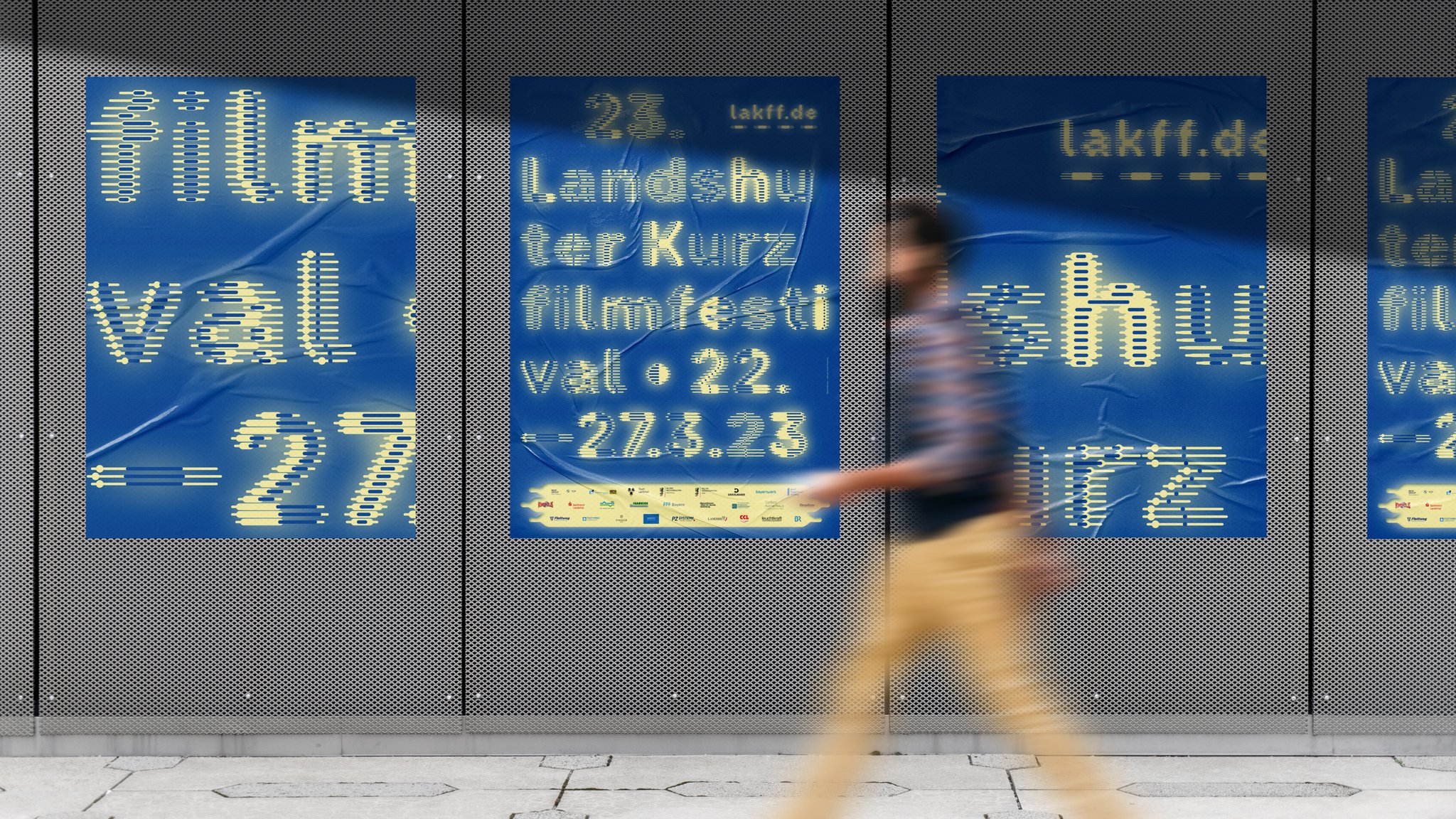 Ein Mann geht an Plakaten des Landshuter Kurzfilmfestivals vorbei