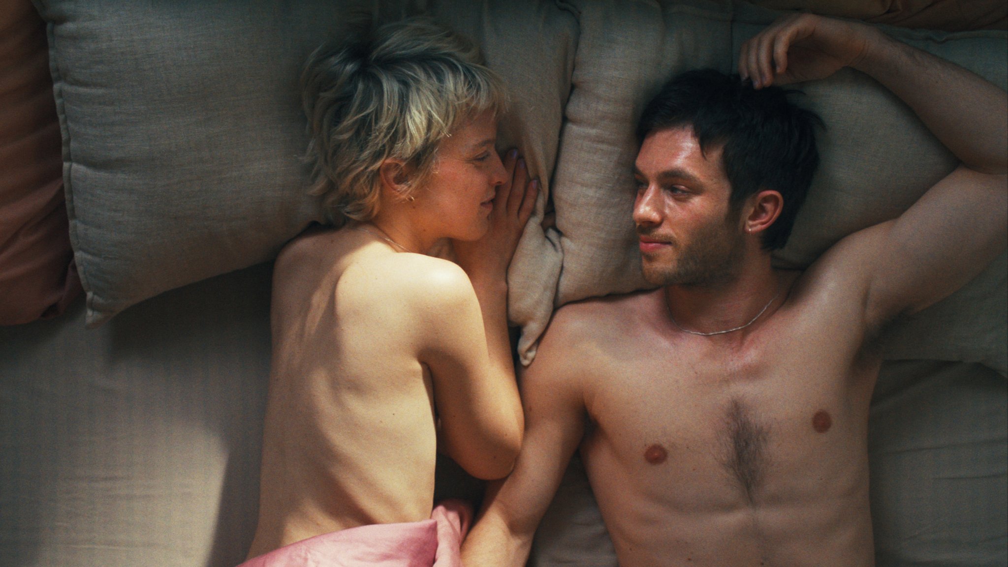 Sylvaine Faligant und Jannis Niewöhner als Paar liegen nackt im Bett in "Allegro Pastell" (Filmszene).