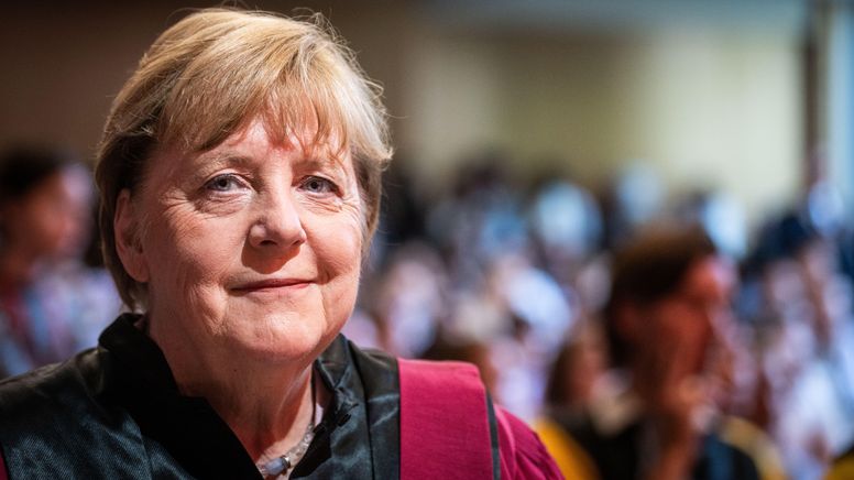 Angela Merkel beim Empfang einer Ehrendoktorwürde in Paris im Juni 2023. Dabei trägt sie eine schwarze Bluse mit rotem Besatz und lächelt in die Kamera. Im Hintergrund ist verschwommen das Publikum der Veranstaltung zu sehen. | Bild:Xose Bouzas/Picture Alliance