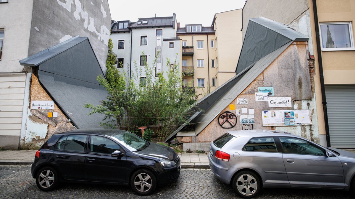 02.05.2022, Bayern, München: Autos parken vor einer Häuserlücke, in der bis 2017 das denkmalgeschützte Uhrmacherhäusl gestanden hat. 