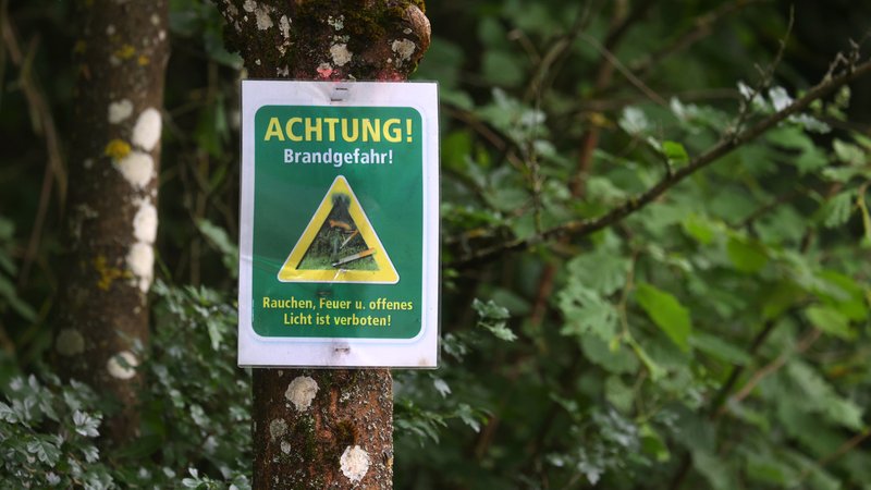(Symbolbild) Ein Schild mit der Aufschrift "Achtung! Brandgefahr! - Rauchen, Feuer und offenes Licht ist verboten" hängt in einem Wald an einem Baum. | Bild: picture alliance/dpa | Karl-Josef Hildenbrand (Symbolbild) Ein Schild mit der Aufschrift "Achtung! Brandgefahr! - Rauchen, Feuer und offenes Licht ist verboten" hängt in einem Wald an einem Baum.