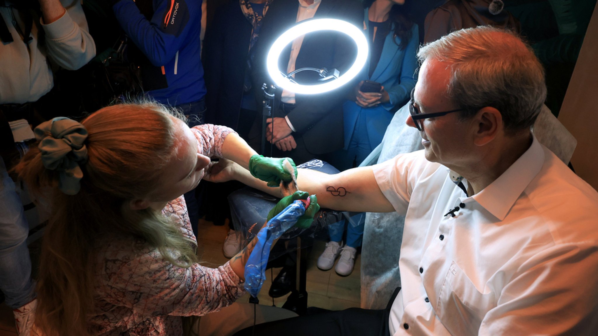 Thomas Zöller von den Freien Wählern, Patientenbeauftragter der bayerischen Staatsregierung, lässt sich in einem Tattoo-Studio ein OptInk-Symbol stechen, welches die Zustimmung zu einer Organspende ausdrücken soll.