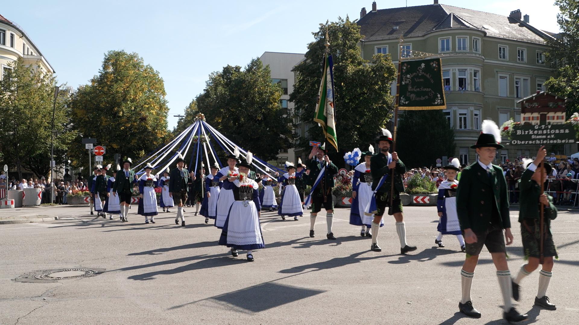 Eine Trachtengruppe im Trachten- und Schützenzug mit Standarten und geschmückten Bändern. 9.000 Menschen nahmen am Trachten- und Schützenzug zum Oktoberfest teil.