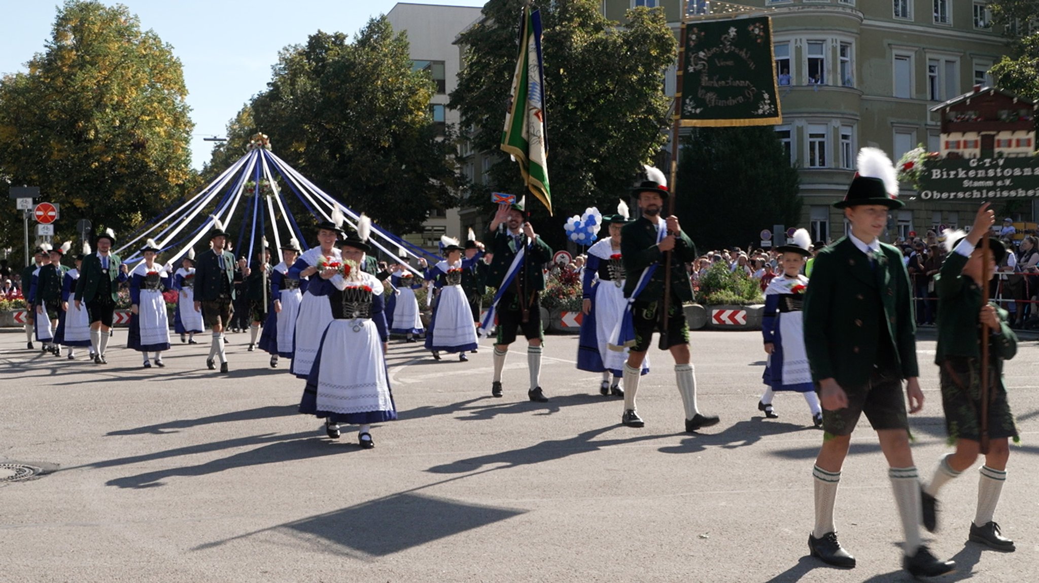 Eine Trachtengruppe im Trachten- und Schützenzug mit Standarten und geschmückten Bändern. 9.000 Menschen nahmen am Trachten- und Schützenzug zum Oktoberfest teil.