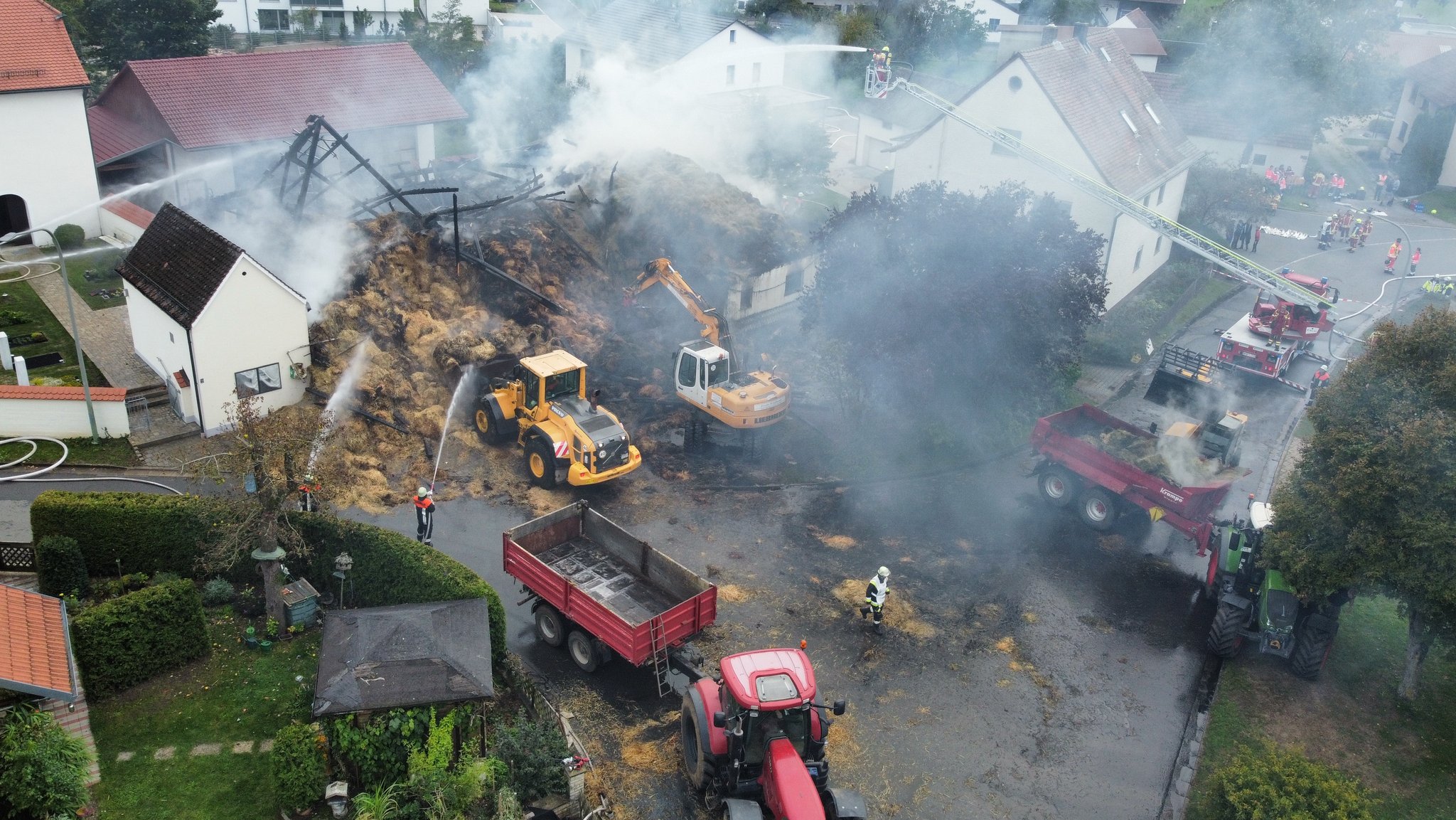 Blick von oben auf die ausgebrannte Scheune in Thundorf und die Helfer im Einsatz