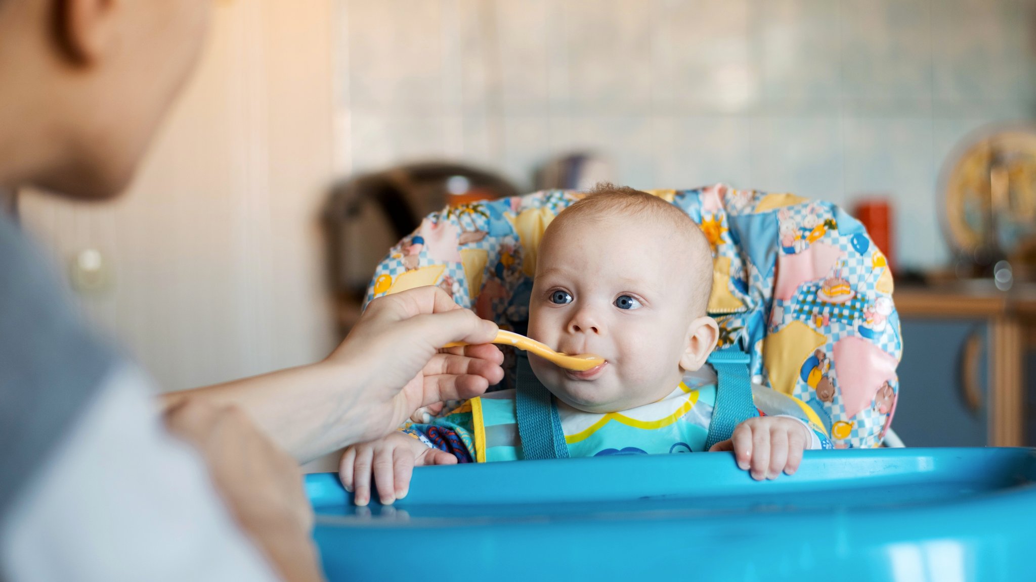 Eine Mutter füttert ihr Baby mit einem Löffel.