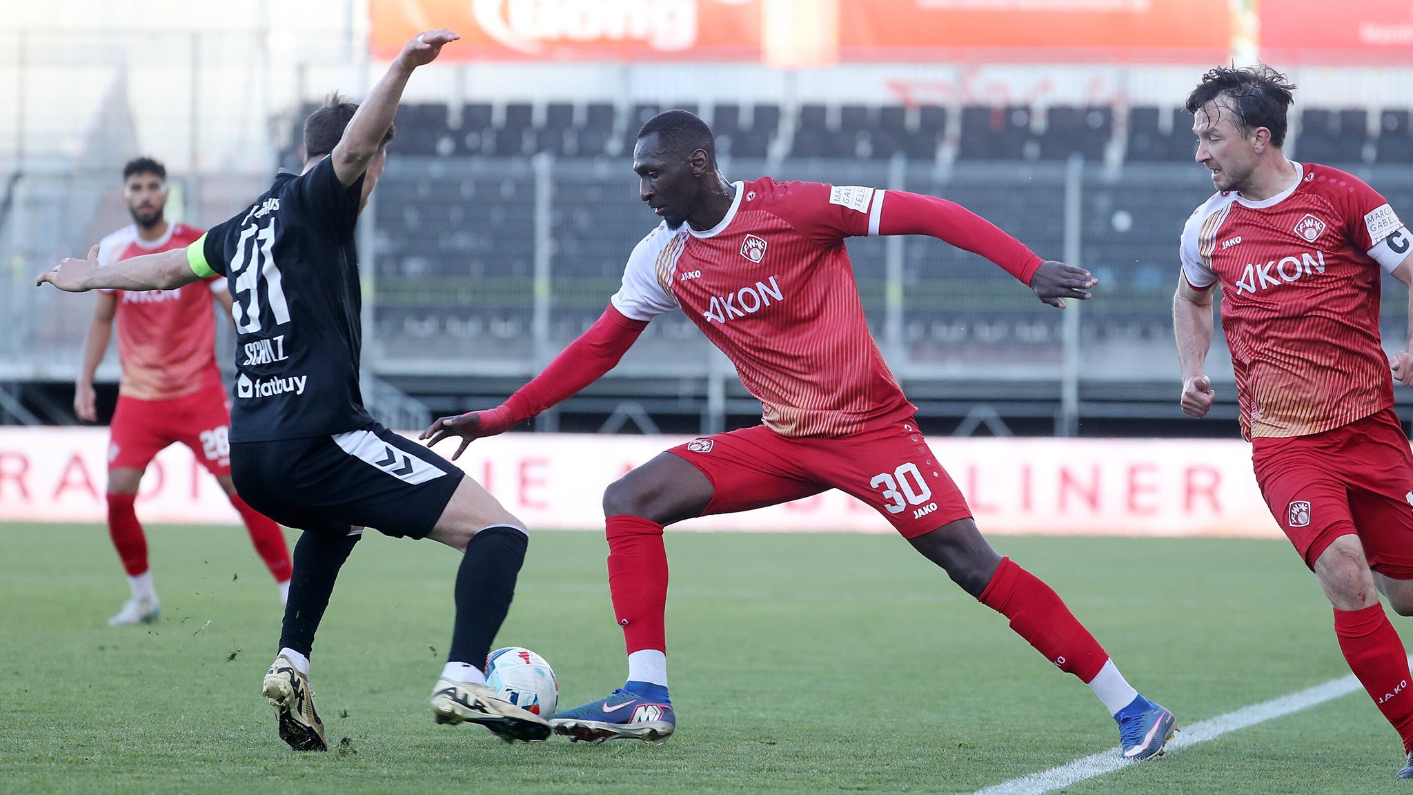 Christoph Schulz (Burghausen) im Zweikampf mit Tarsis Bonga (Kickers)