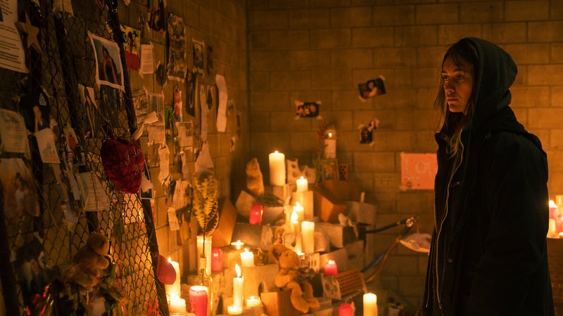 Das obdachlose Mädchen Tyler steht vor einer Kellerwand, die mit Andenken und Fotos behängt ist in einer Szene aus der Serie "Katakomben" von Joyn.