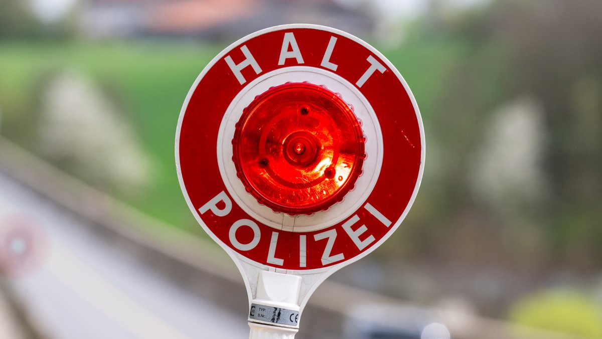 Bayern, Viechtach: Eine Kelle mit der Aufschrift "Halt Polizei" wird während einer Verkehrskontrolle hochgehalten. 