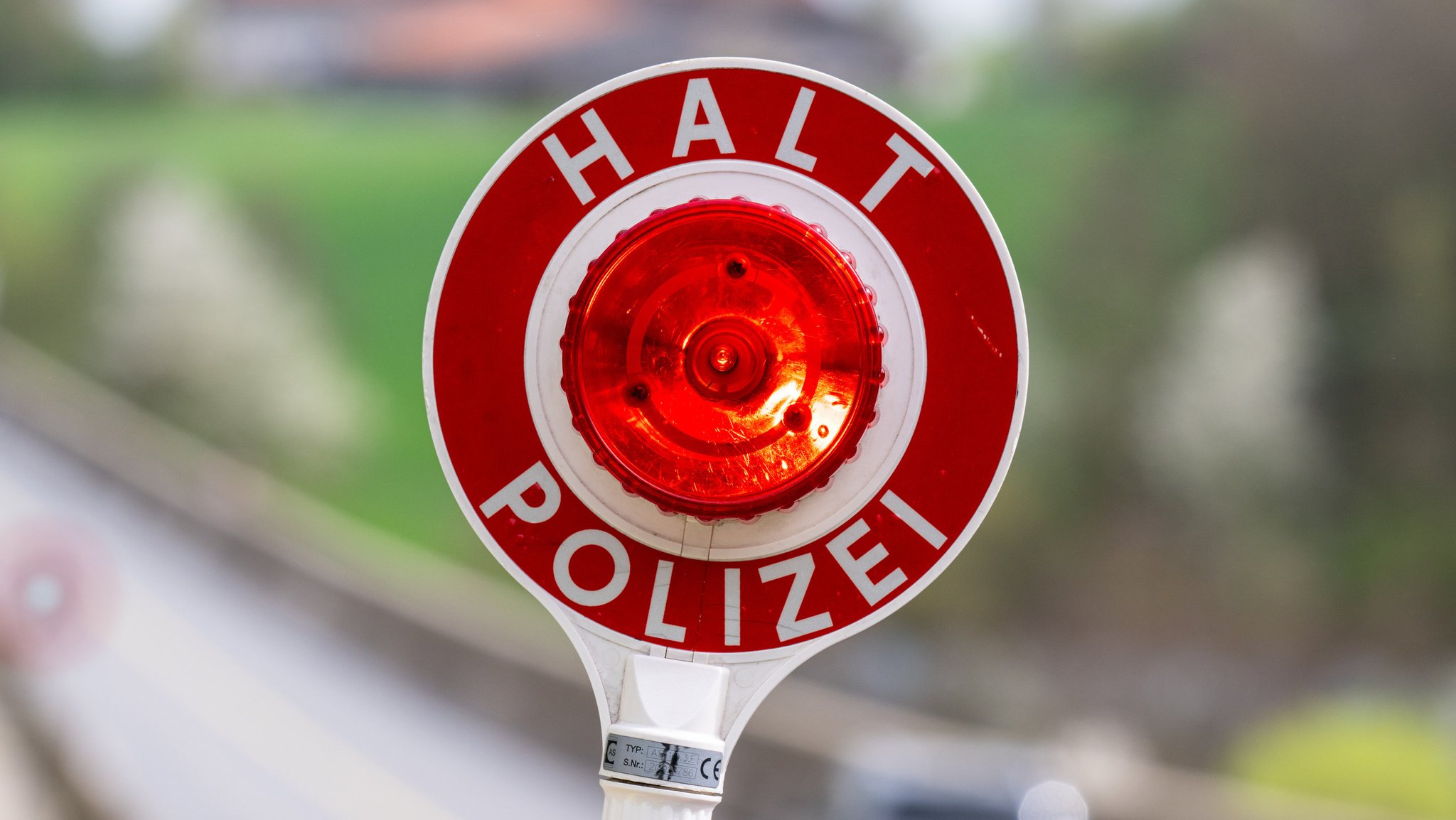 Bayern, Viechtach: Eine Kelle mit der Aufschrift "Halt Polizei" wird während einer Verkehrskontrolle hochgehalten. 