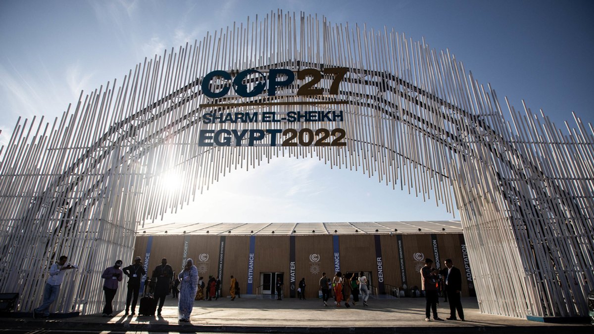 Menschen stehen bei dem Eingang des Internationalen Kongresszentrums, wo die UN-Klimakonferenz COP27 stattfinden wird.