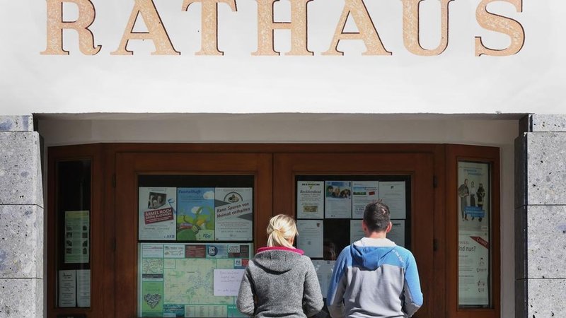 Eine Frau und ein Mann betreten das Rathaus, um bei der Kommunalwahl ihre Stimmen abzugeben. (zu dpa: «Ehrenamt oder Hauptamt? Bürgermeister in kleinen Gemeinden») Foto: Karl-Josef Hildenbrand/dpa +++ dpa-Bildfunk +++