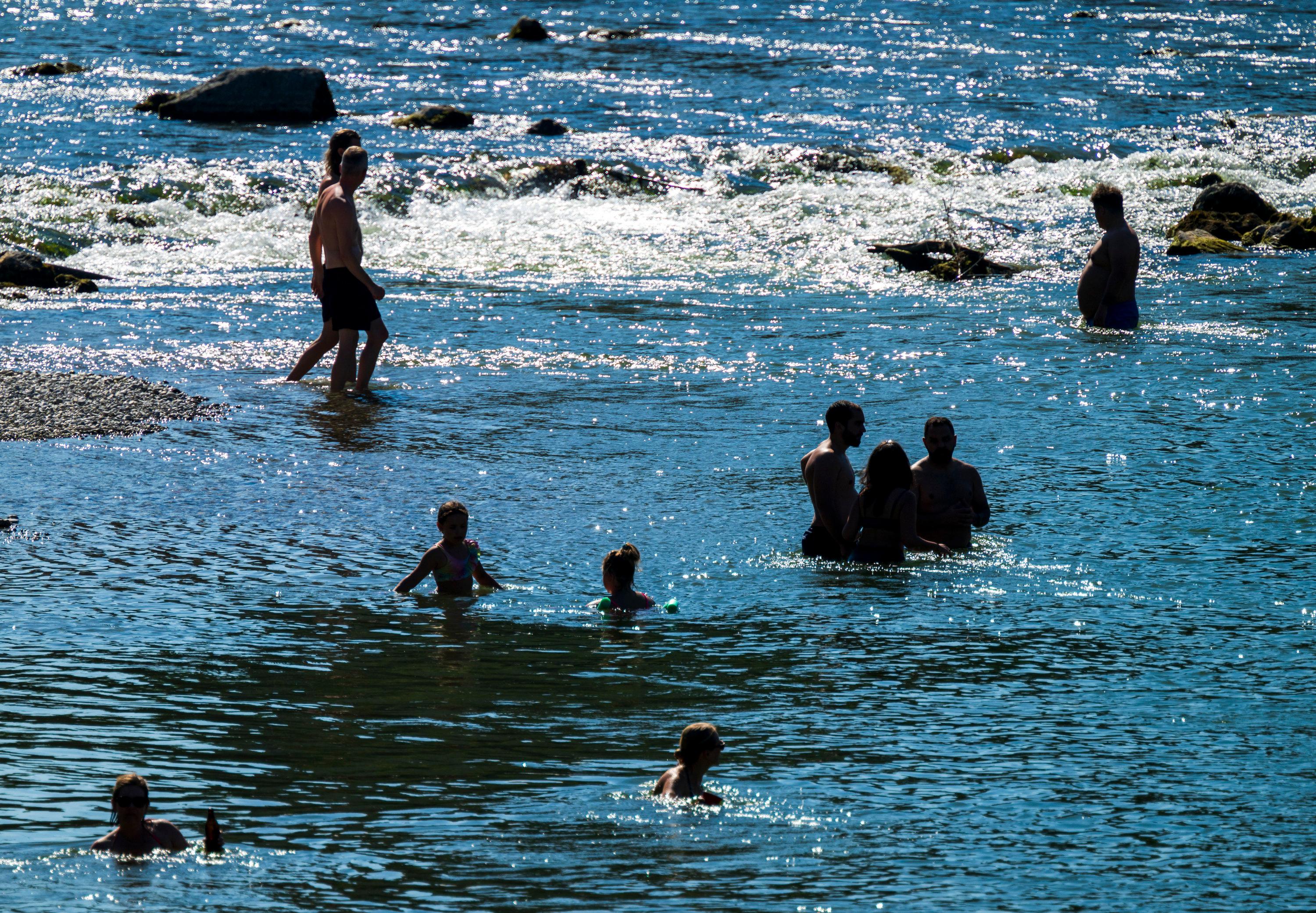 Badende kühlen sich an und in der Isar ab.