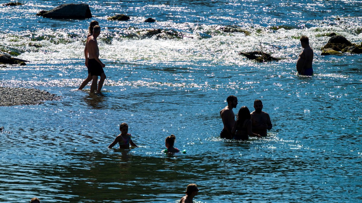 Badende kühlen sich an und in der Isar ab.