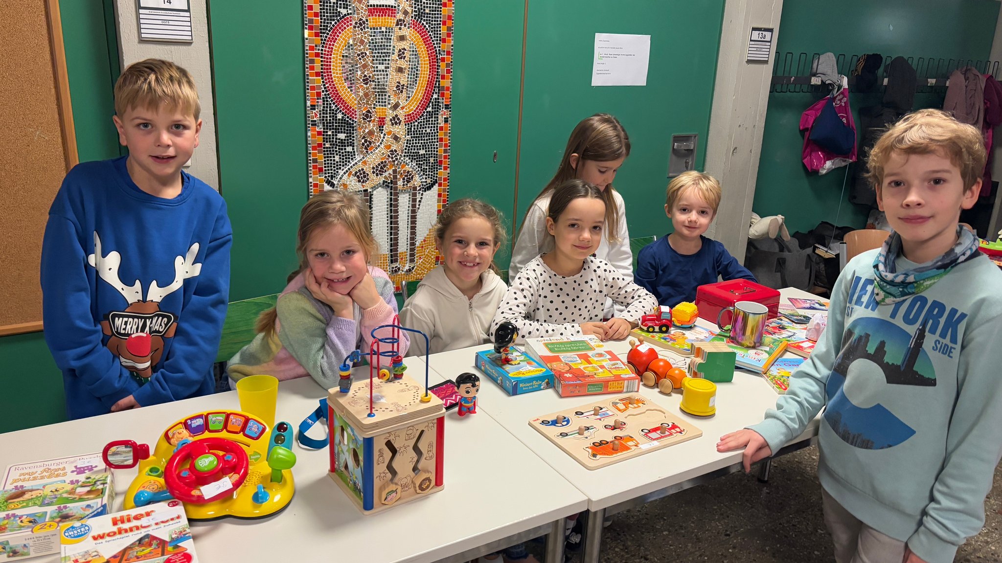 Schülerinnen und Schüler der Graf-Heinrich Grundschule in Kaisheim stehen vor einem Tisch mit Spielsachen und Büchern. Sie verkaufen die Dinge für den guten Zweck, der Erlös geht an die Sternstunden.