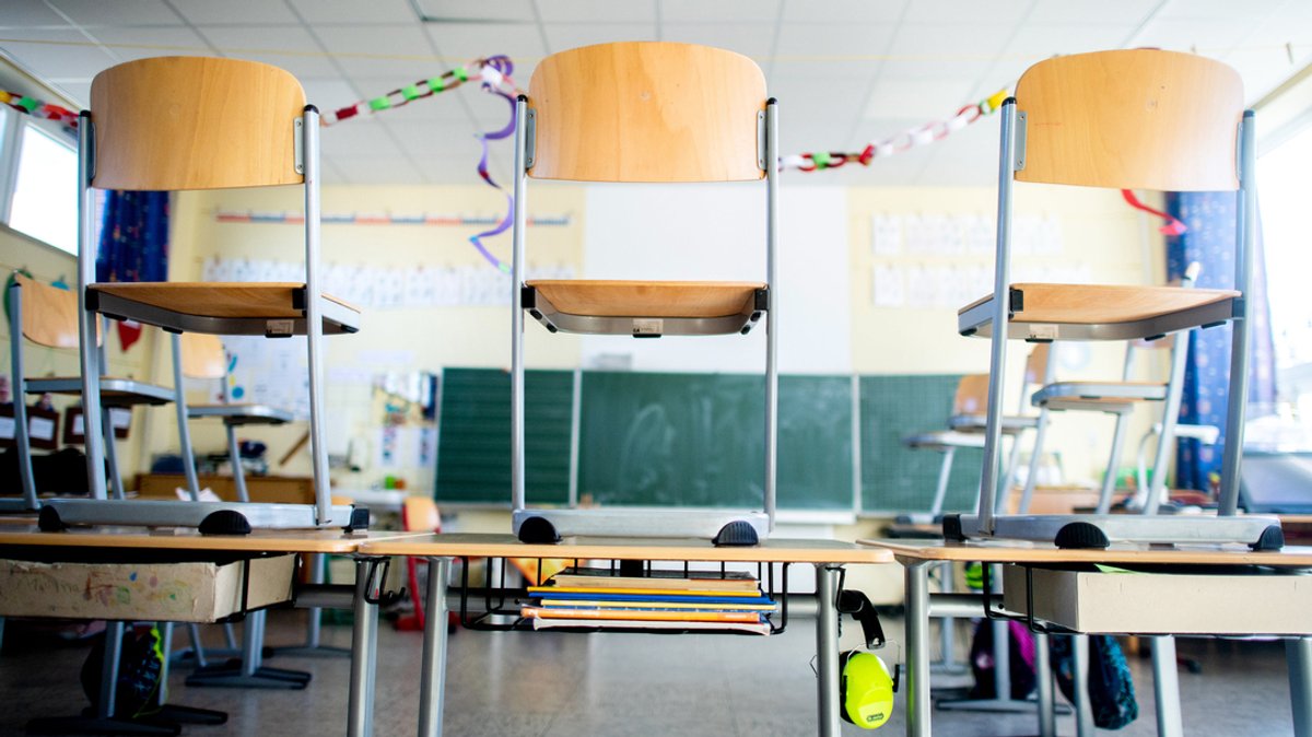 Stühle stehen auf den Tischen in einem Unterrichtsraum einer Grundschule. 