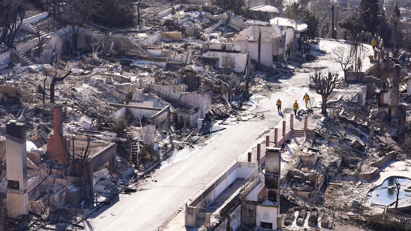 Feuerwehrleute laufen zwischen zerstörten Häusern in Los Angeles im Januar 2025. | Bild: picture alliance / Anadolu | Lokman Vural Elibol Feuerwehrleute laufen zwischen zerstörten Häusern in Los Angeles im Januar 2025.