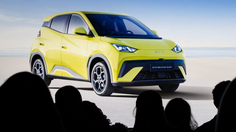 Auf einem Bildschirm ist der gelbe Kleinwagen "Dolphin Surf" zu sehen, davor Silhouette der Köpfe von IAA Mobility-Besuchern | Bild: picture alliance/KEYSTONE | MICHAEL BUHOLZER Auf einem Bildschirm ist der gelbe Kleinwagen "Dolphin Surf" zu sehen, davor Silhouette der Köpfe von IAA Mobility-Besuchern