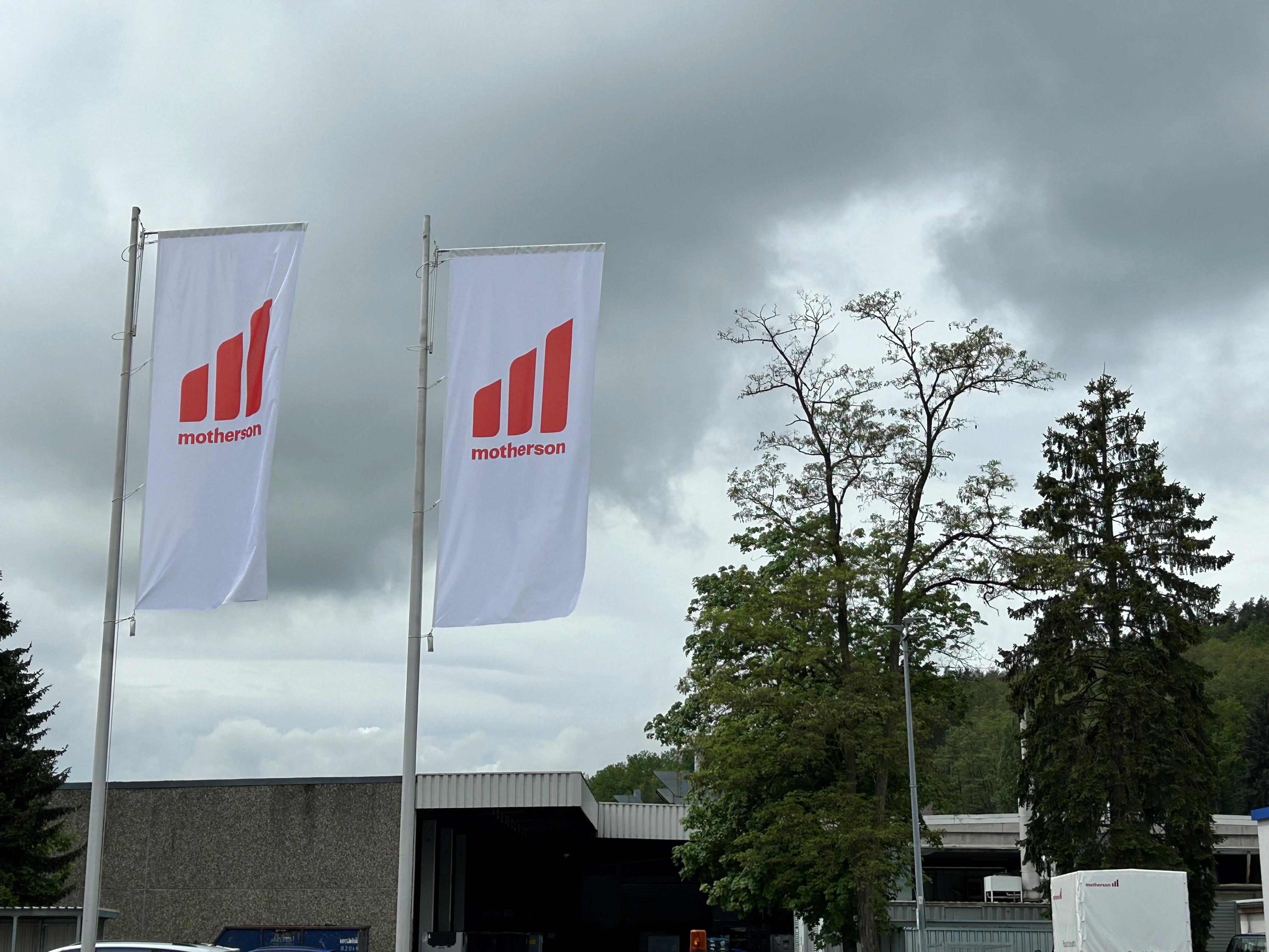 Fahnen wehen im Wind vor einem dunklen Wolkenhimmel.